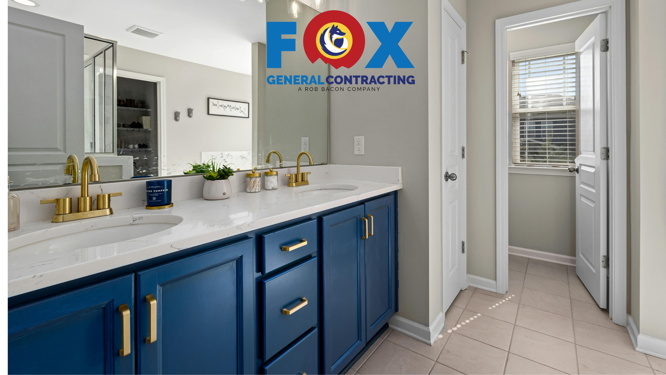 Modern bathroom remodel with blue double vanity, gold fixtures and white quartz countertop by Fox General Contracting in Fairhope, AL.